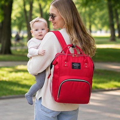 maman porte bébé avec sac à dos à langer imperméable top