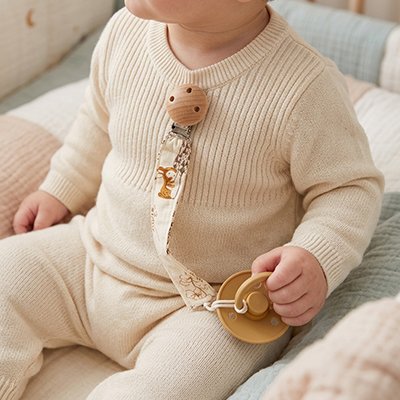 attache tetine fixée sur le vêtement de bébé