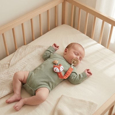 attache tétine bébé mignon fixée sur le vêtement de bébé qui dort