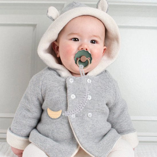 attache tetine crochet chou fixée sur vêtement de bébé