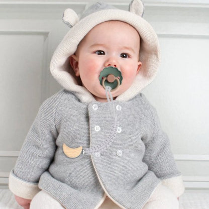 attache tetine crochet chou fixée sur vêtement de bébé