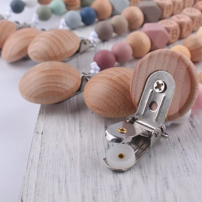 attache tetine en bois fiable avec clip métallique sur la table