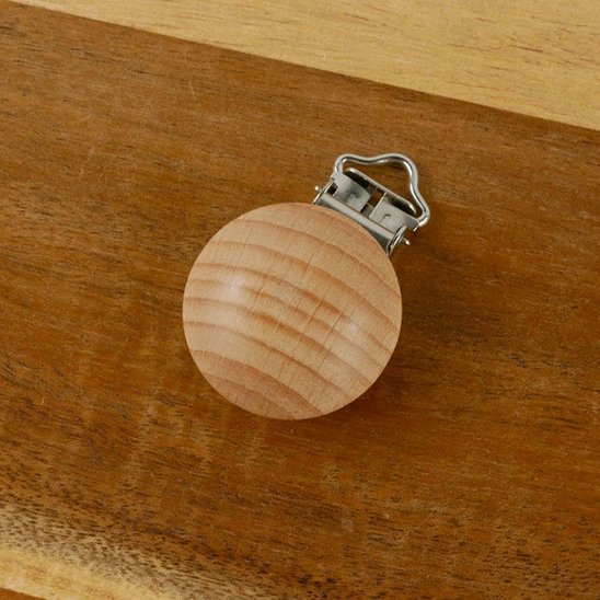 attache tetine en bois fiable sur la table