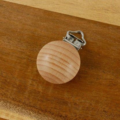 attache tetine en bois fiable sur la table