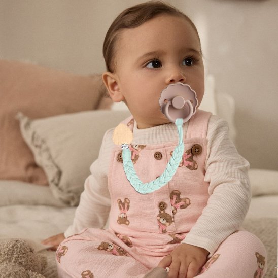 bébé assis sur le lit porte attache tetinecrochet  chou