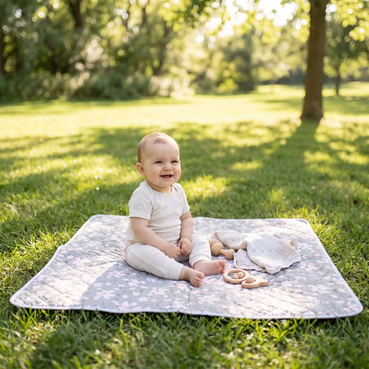bébé assis sur tapis pour table a langer lavable au parc
