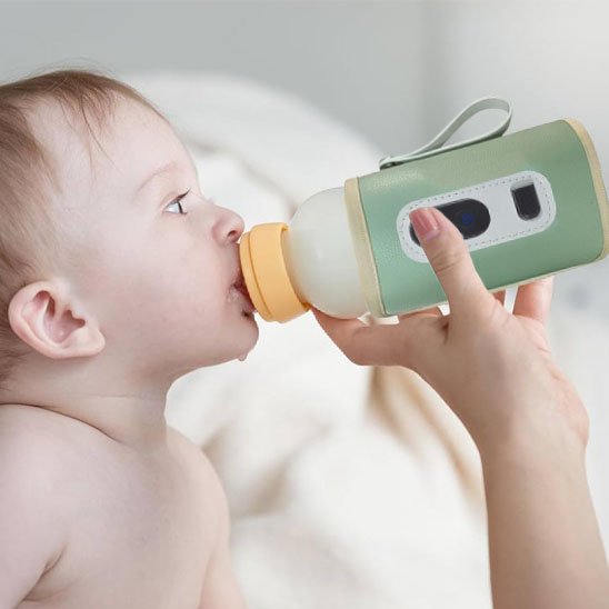bébé boit du biberon dans chauffe biberon nomade ultra-rapide