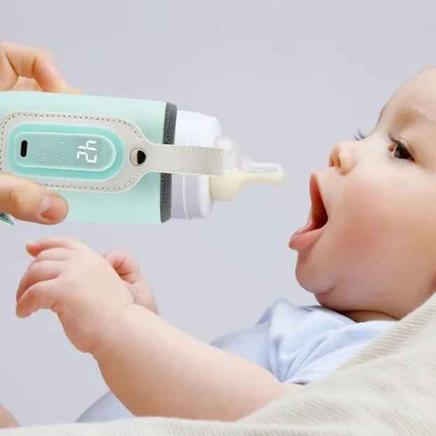 bébé boit du biberon dans chauffe biberon portatif vif