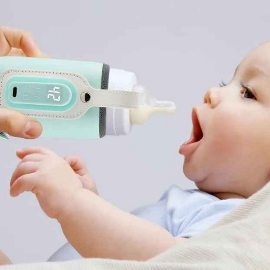 bébé boit du biberon dans chauffe biberon portatif vif