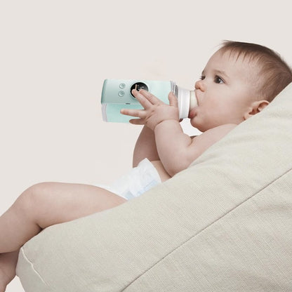 bébé boit du biberon dans chauffe biberon voyage compact intelligent
