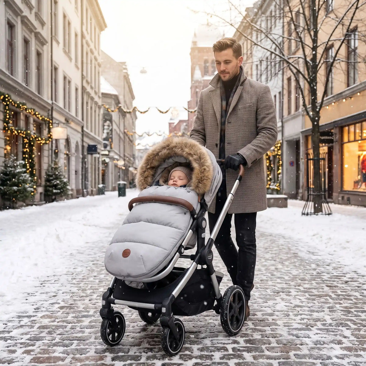bébé dans chanceliere hiver poussette doudoune en ville avec papa