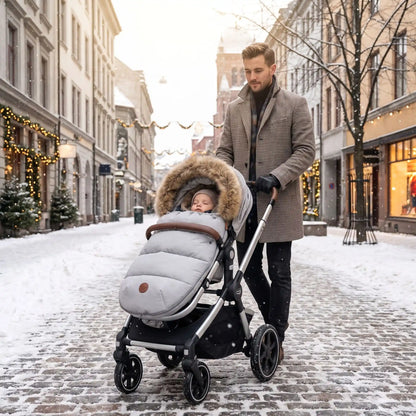 bébé dans chanceliere hiver poussette doudoune en ville avec papa