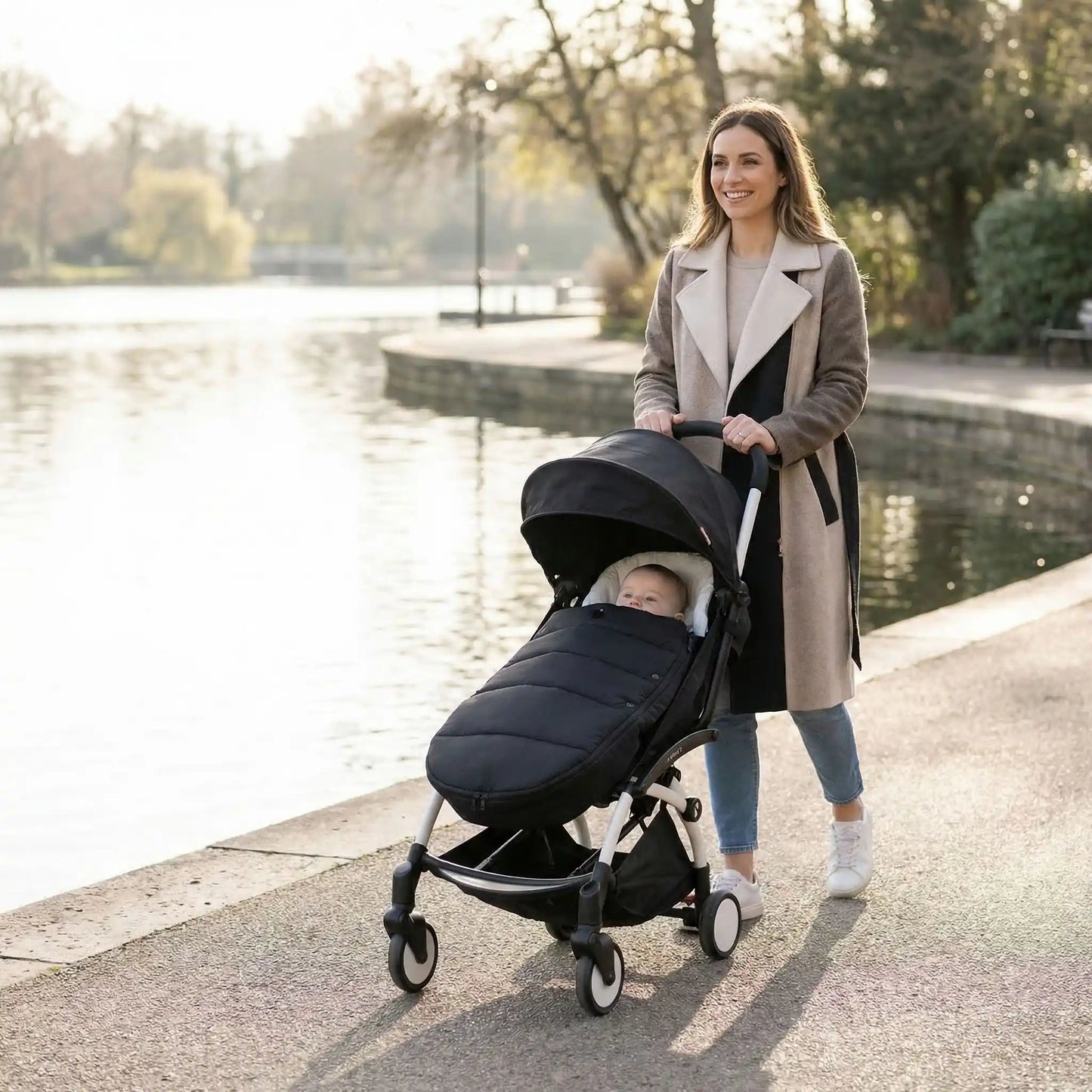 bébé dans chancelière pour cosy toutes saisons avec maman au bord d'eau