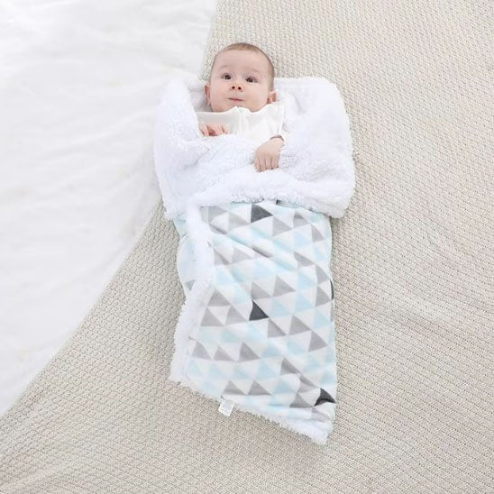 bébé dans couverture poussette hiver tendre sur le lit
