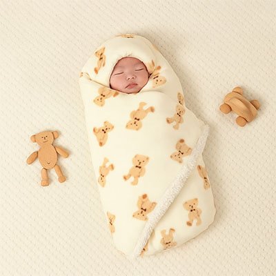 bébé dans couverture poussette moelleux sur tapis