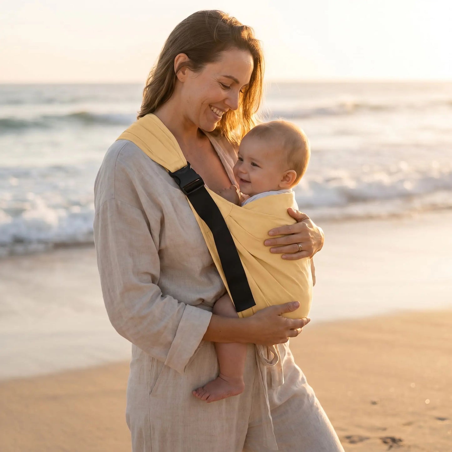 bébé dans l'echarpe de portage été ergocarry avec maman sur la plage