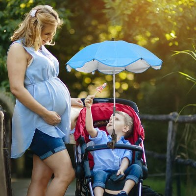 bébé dans la poussette avec ombrelle pour poussette​ universelle avec maman au parc