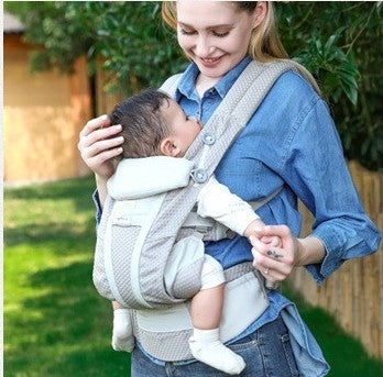 bébé dans porte bebe ergonomique confort dorsal dans le jardin