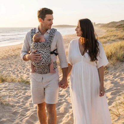 bébé dans porte bebe naissance ajustable sur la plage avec papa et maman