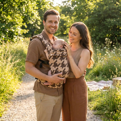 bébé dans porte bébé nouveau né ergobaby au parc avec papa et maman