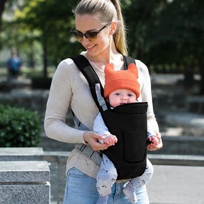 bébé dans porte bebe physio grâce avec maman au parc