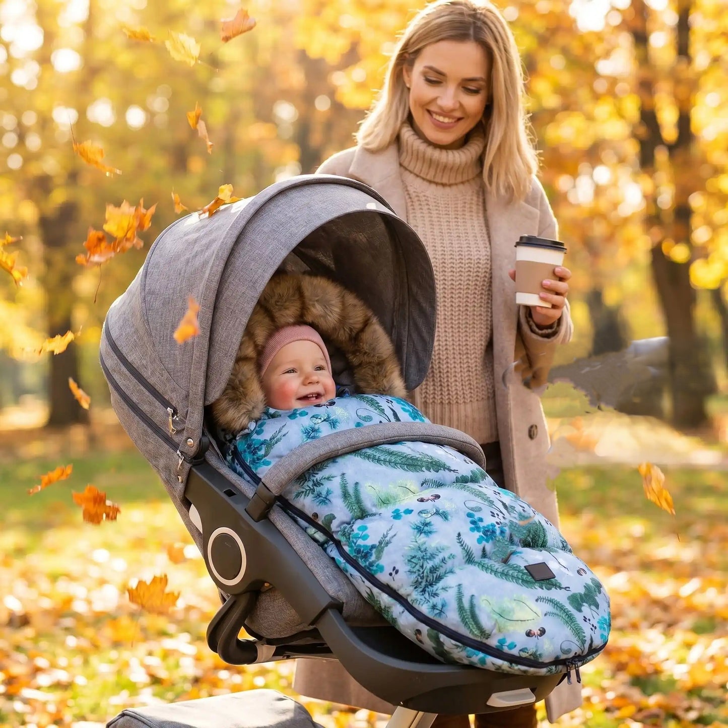 bébé dans une chanceliere chaude pour poussette babyhiver au parc avec maman 