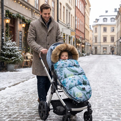 bébé dans une chanceliere chaude pour poussette babyhiver en ville avec papa