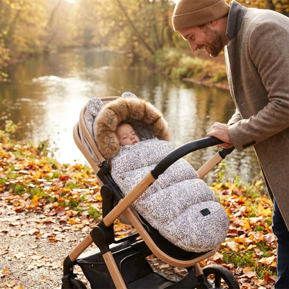 bébé dans une chanceliere chaude universelle cocoon hiver au bord d'eau avec papa