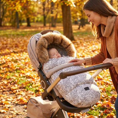 bébé dans une chanceliere chaude universelle cocoon hiver au parc avec maman