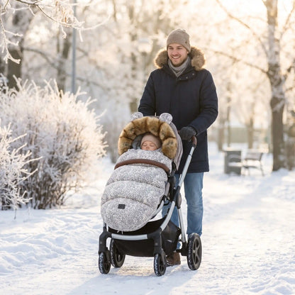 bébé dans une chanceliere chaude universelle cocoon hiver au parc avec papa