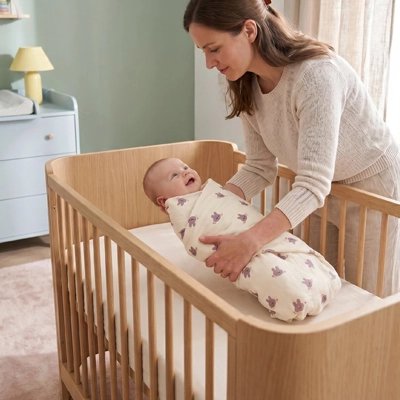 bébé emmaillote dans couverture bebe paisible au berceau