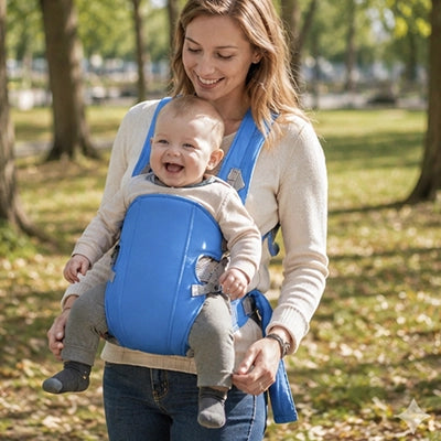 bébé en porte bebe ergonomique vent au parc avec maman