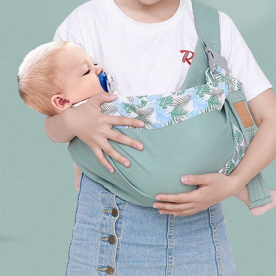 bébé porté sur le coté en echarpe de portage par maman