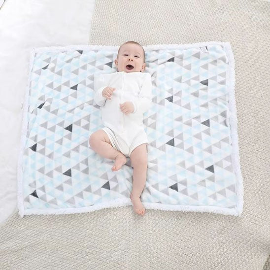bébé sur couverture poussette hiver tendre sur le lit