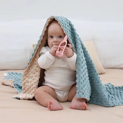 bébé sur le lit avec couverture cosy hiver ouaté