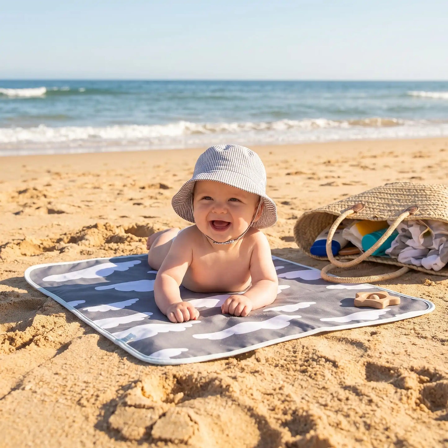 bébé sur tapis à langer nuages à la plage