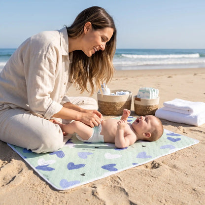 bébé sur tapis à langer voyage hearts sur plage avec maman