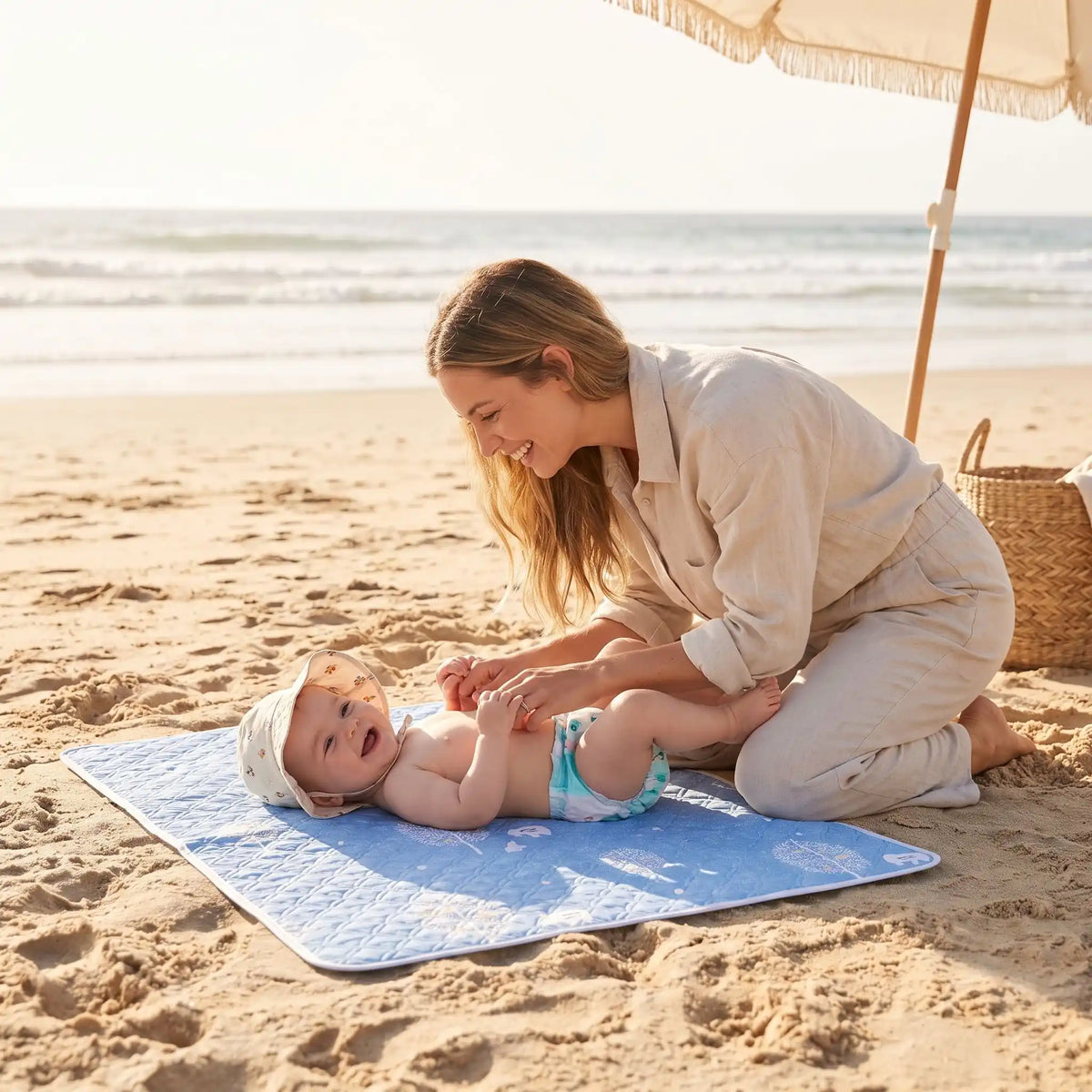 bébé sur tapis change bebe tree sur plage avec maman