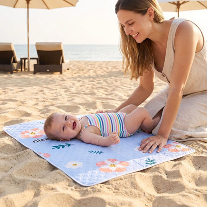 bebe sur tapis pour changer bebe sunflower sur plage avec maman