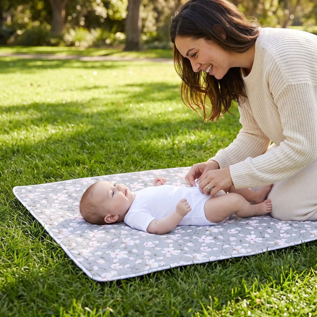 bébé sur tapis pour table a langer lavable au parc avec maman