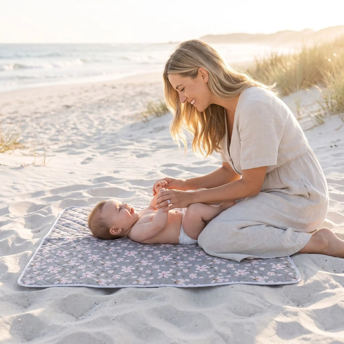 bébé sur tapis pour table a langer lavable sur la plage avec maman