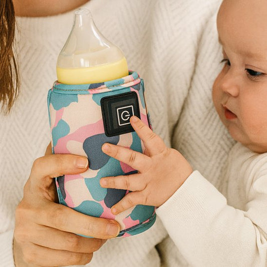 bébé tient biberon dans chauffe biberon portable nomade perfect