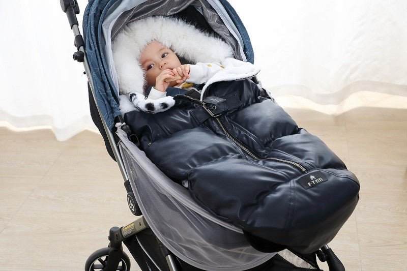 bébé dans chanceliere bebe thermo - confort au poussette joue avec un jouet dans ses mains