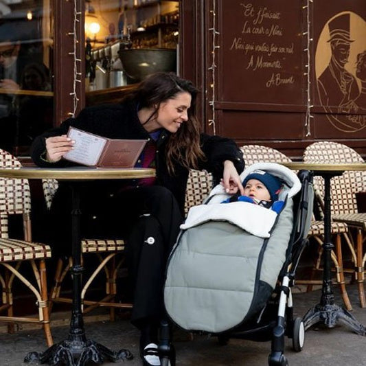 bébé dans chancelière poussette | Ultra - isolante   avec maman  assise sur une chaise au café restaurant