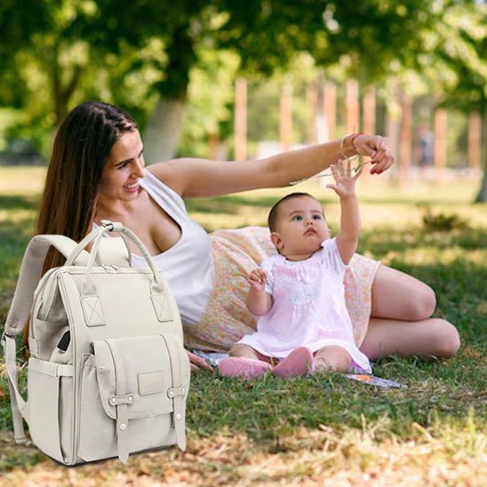 bébé joue avec maman au parc sac à langer momélégance à coté d'eux