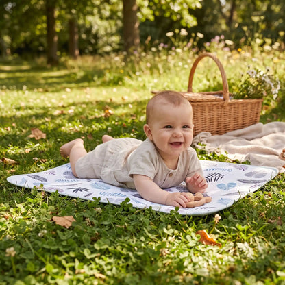 bébé joue sur tapis à langer nomade feuilles au parc