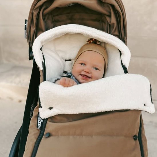  bébé souriant dans chancelière poussette ultra isolante