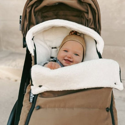  bébé souriant dans chancelière poussette ultra isolante