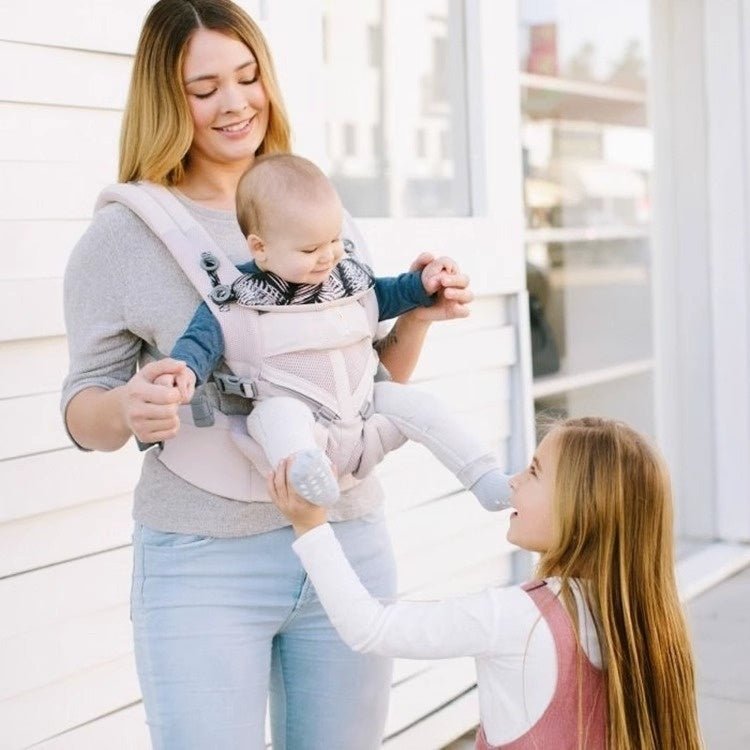 maman avec bébé dans porte bebe physio comfort ergonomique avec sa soeur