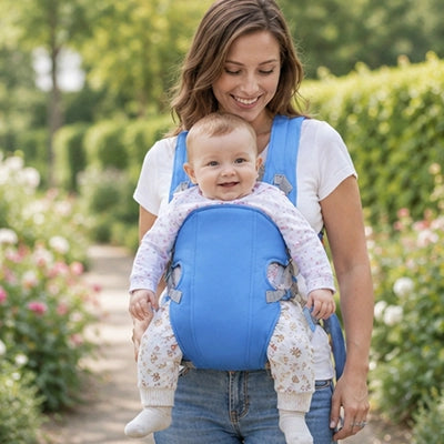 maman avec bébé en porte bebe ergonomique vent au jardin